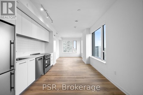A modern kitchen with white cabinets and stainless steel appliances.