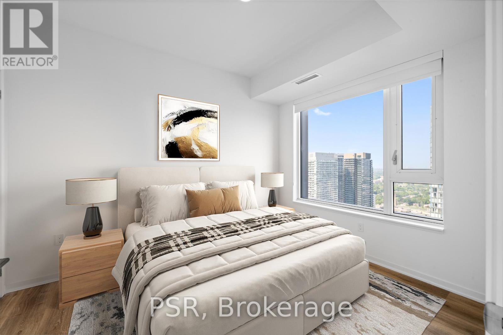 A bedroom with a large bed and a painting on the wall.