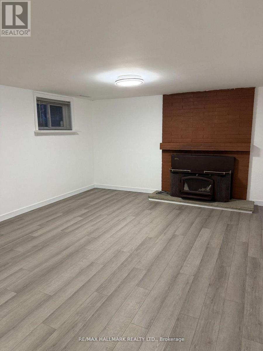 A room with a fireplace and wooden flooring.