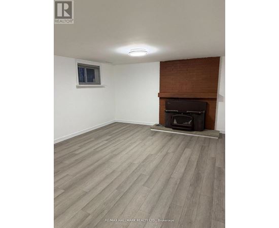 A room with a fireplace and wooden flooring.