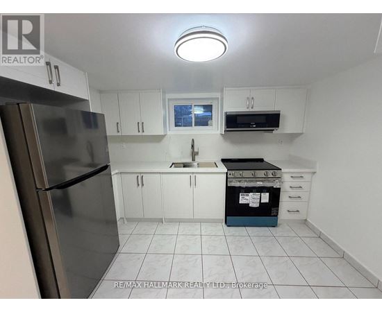 A kitchen with white cabinets and a stainless steel refrigerator.