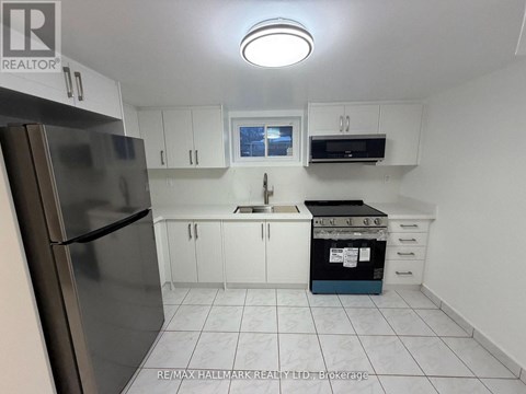 A kitchen with white cabinets and a stainless steel refrigerator.