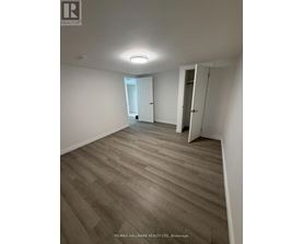 A room with wooden flooring and white walls.