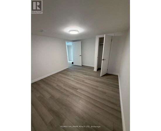 A room with wooden flooring and white walls.