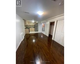 A room with wood flooring and white walls.