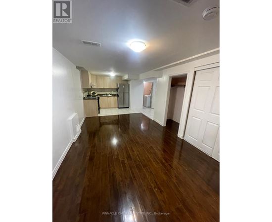A room with wood flooring and white walls.