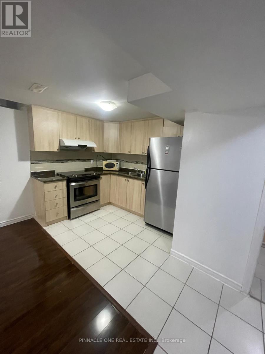 A kitchen with a refrigerator, oven, and microwave.
