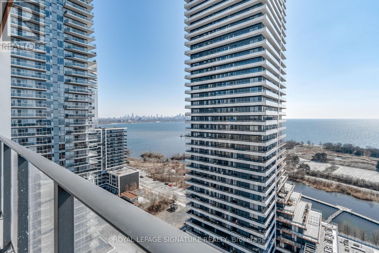 A tall building with a balcony overlooking a body of water.