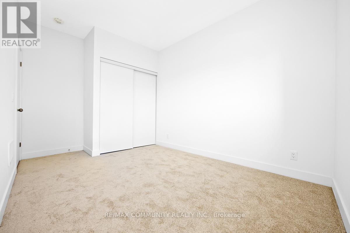 A white bedroom with a carpet floor and a white door.
