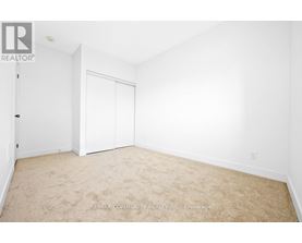 A white bedroom with a carpet floor and a white door.