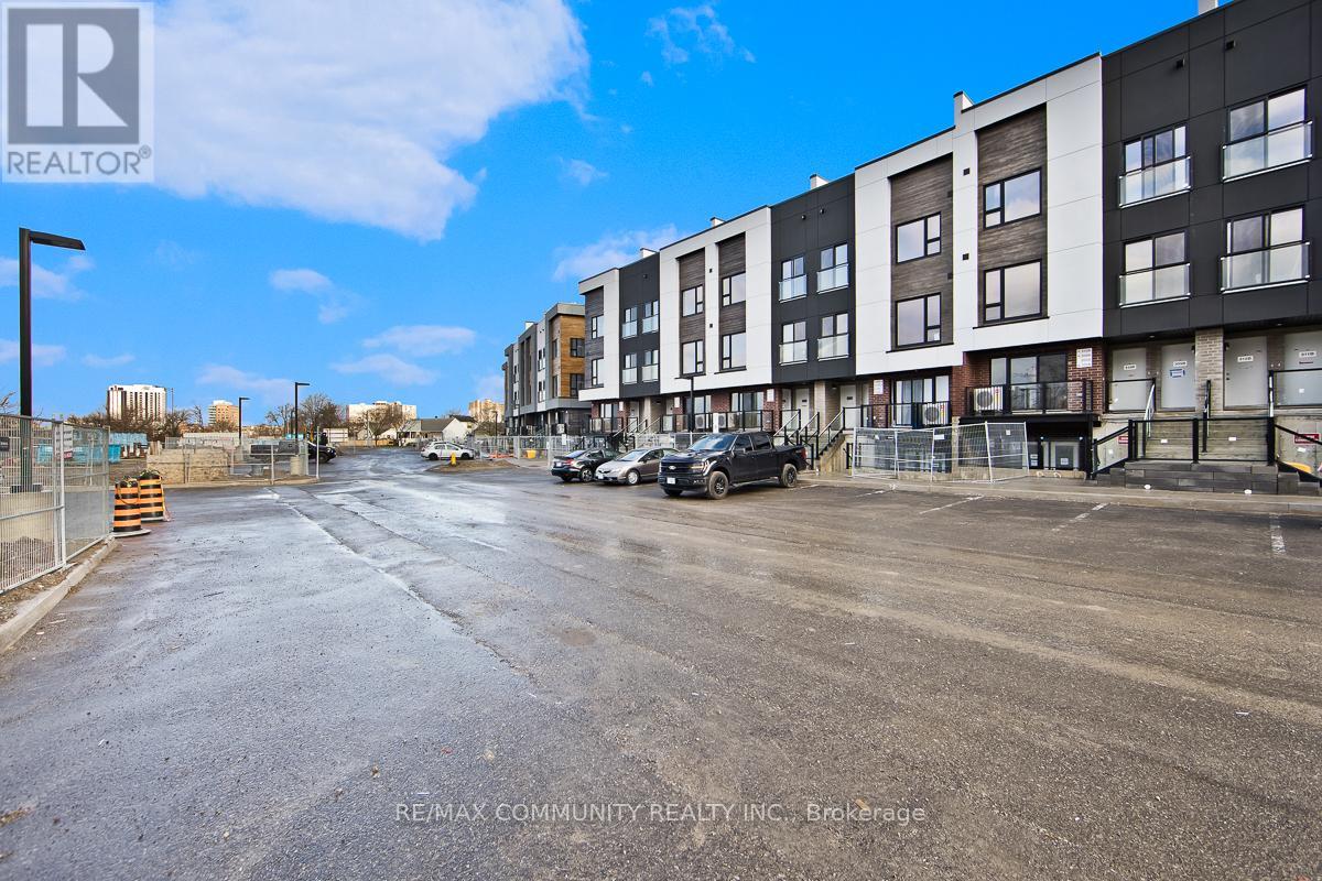 A street view of a residential area with apartment buildings and cars parked on the side.