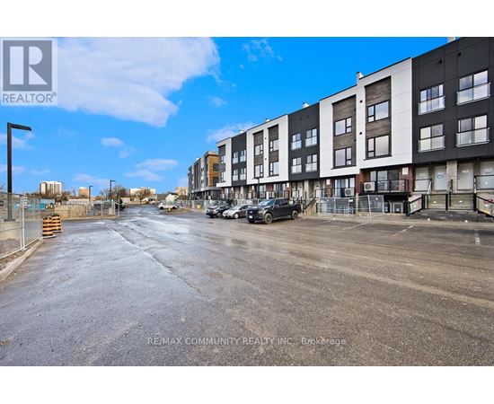 A street view of a residential area with apartment buildings and cars parked on the side.