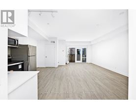 A spacious, empty room with a refrigerator and a white countertop.