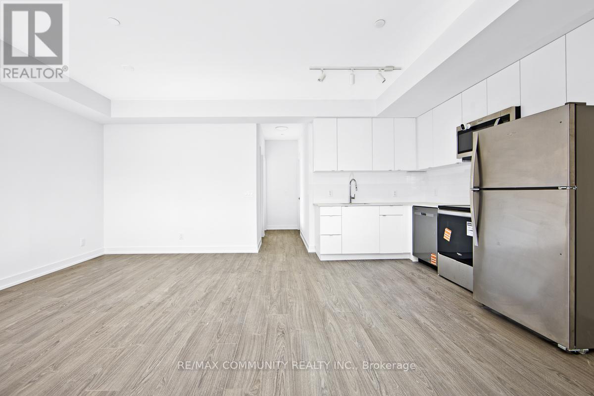 A kitchen with white cabinets and a wooden floor.