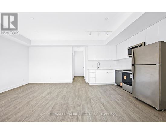 A kitchen with white cabinets and a wooden floor.