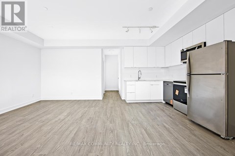 A kitchen with white cabinets and a wooden floor.
