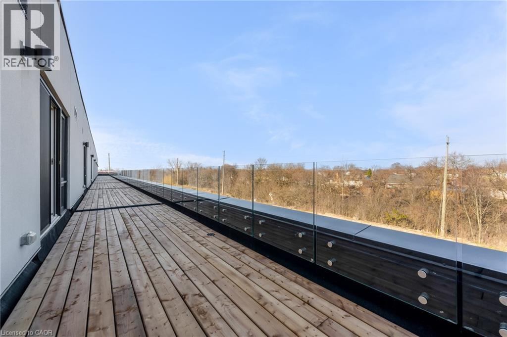 A wooden deck with a metal railing and a building on the left.