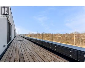 A wooden deck with a metal railing and a building on the left.