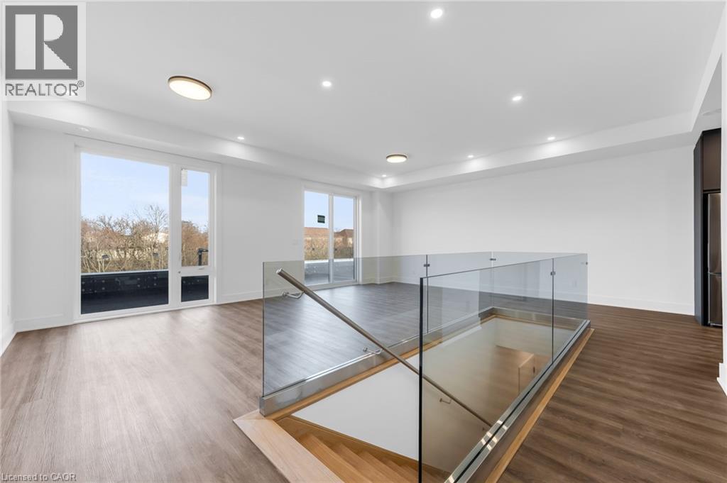 A spacious room with a glass railing and wooden flooring.