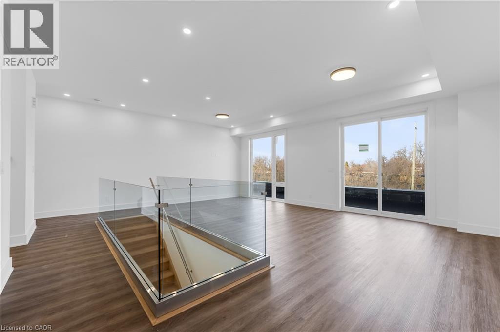 A spacious room with a glass partition wall and wooden flooring.