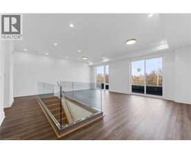 A spacious room with a glass partition wall and wooden flooring.