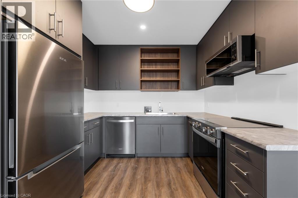 A modern kitchen with stainless steel appliances and wooden floors.