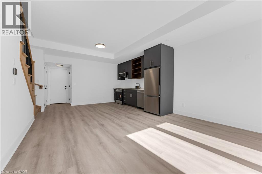 A kitchen area with a refrigerator, oven, and microwave.