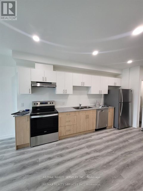 A kitchen with white cabinets and a stainless steel refrigerator.