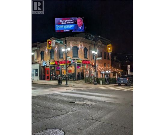 A street view with a billboard that says "Merry Christmas" and a website address.