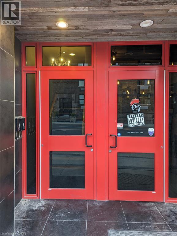 A red door with a glass window and a sign that says "PARENTAL ADVISORY".