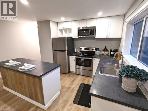 A modern kitchen with a wooden island and stainless steel appliances.