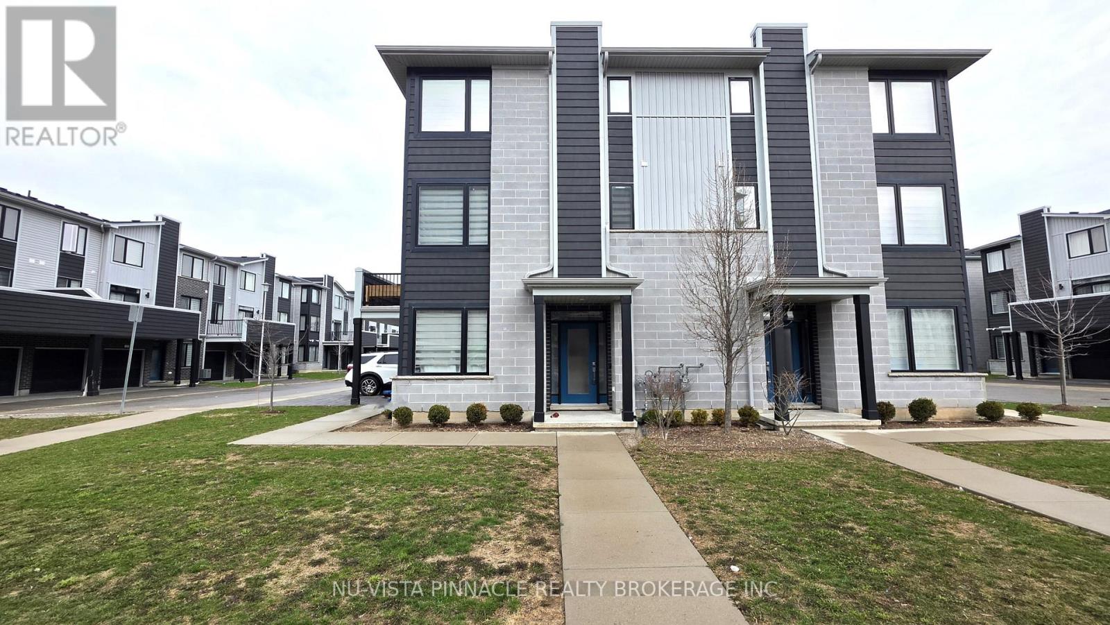 A modern two-story house with a blue door and windows.