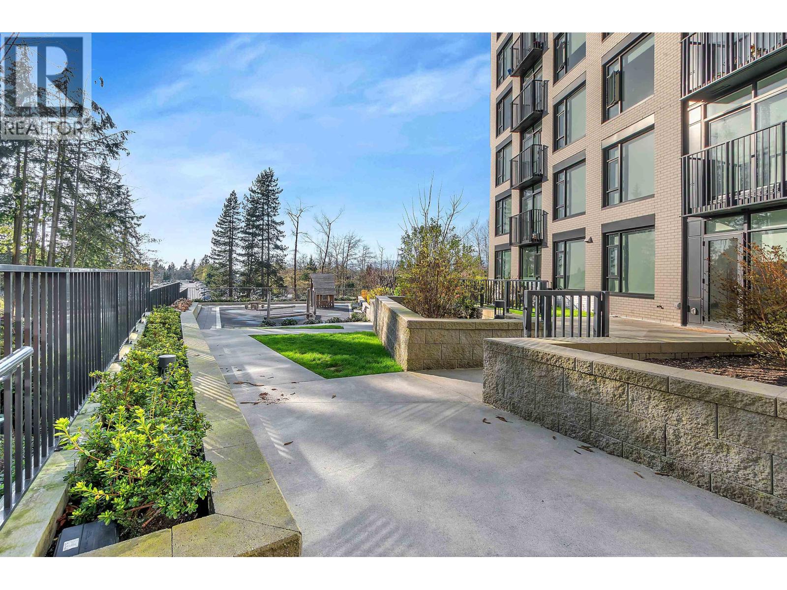 A residential street with a sidewalk and apartment buildings.
