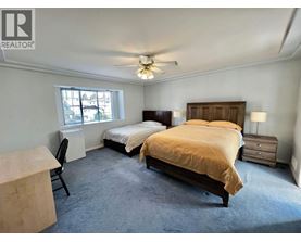 A bedroom with two beds and a ceiling fan.