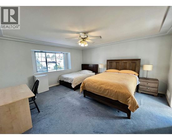 A bedroom with two beds and a ceiling fan.