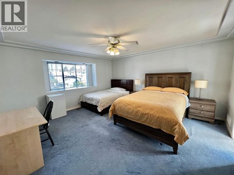 A bedroom with two beds and a ceiling fan.