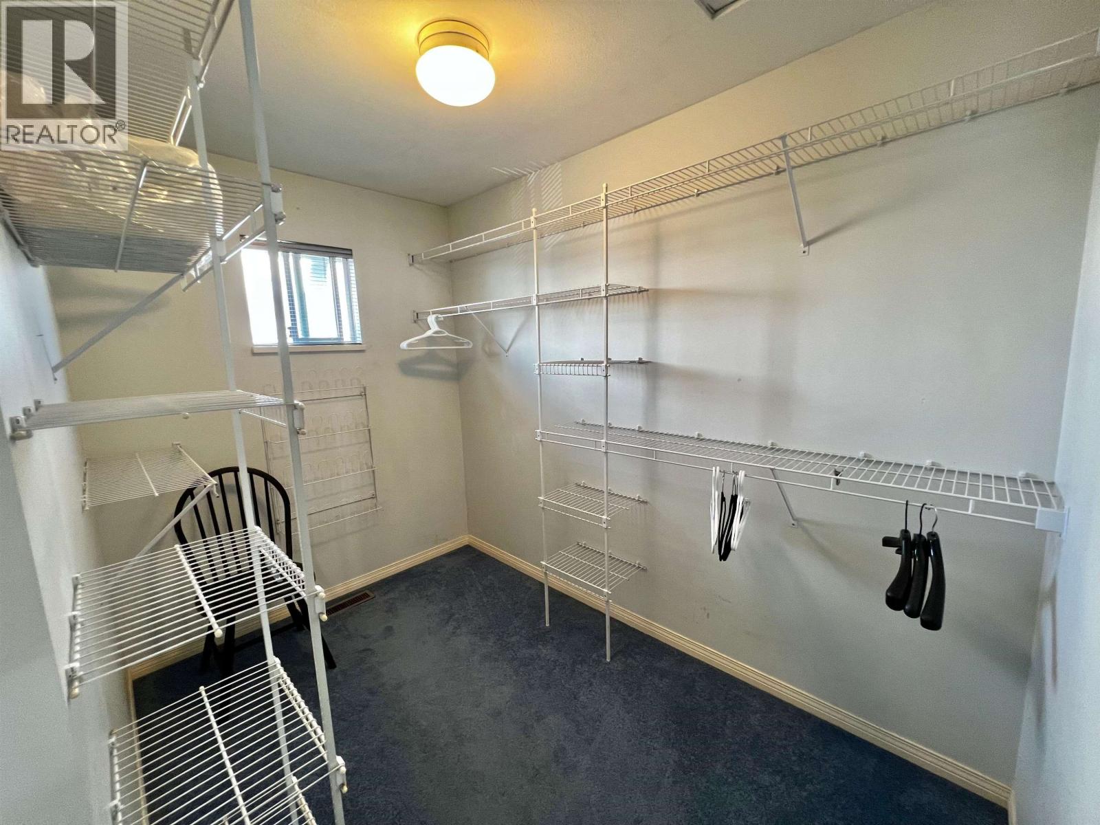 A room with a lot of shelves and a chair.