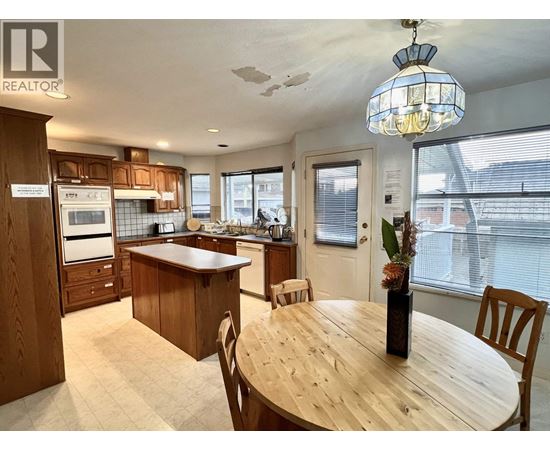 A kitchen with wooden cabinets and a dining table.
