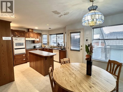 A kitchen with wooden cabinets and a dining table.