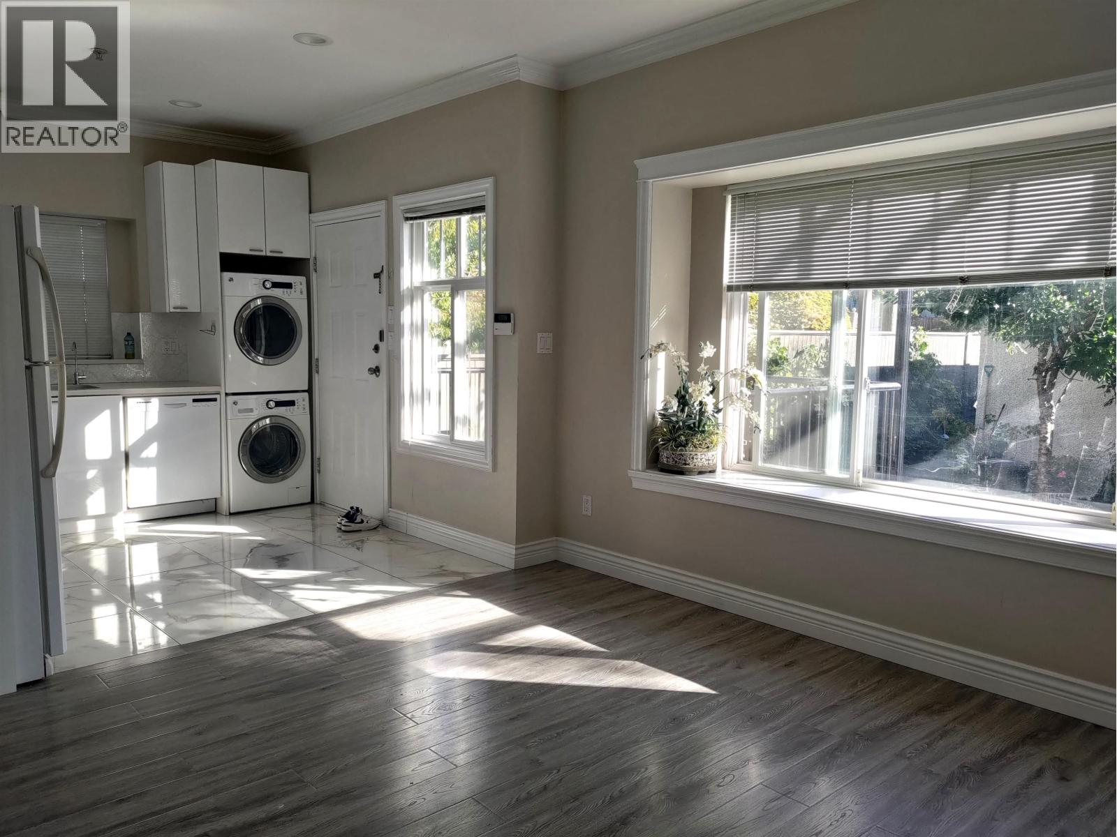 A sunny room with a washer and dryer in it.