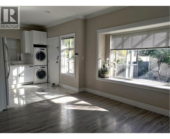 A sunny room with a washer and dryer in it.
