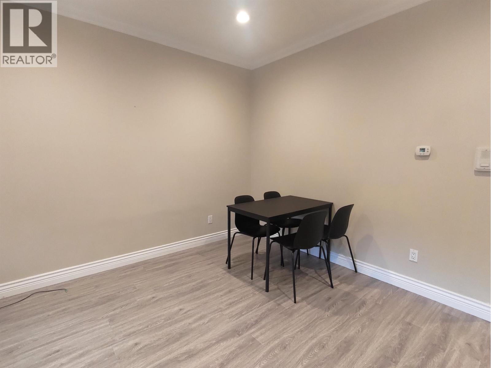 A dining room with a table and chairs.
