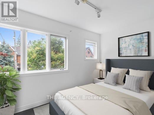 A bedroom with a large bed and a window overlooking a residential area.