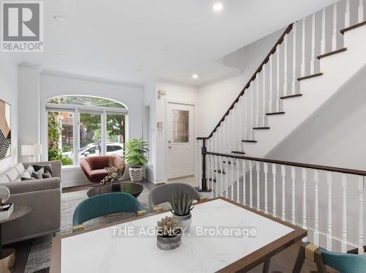 A well-lit living room with a staircase leading to the upper floor.