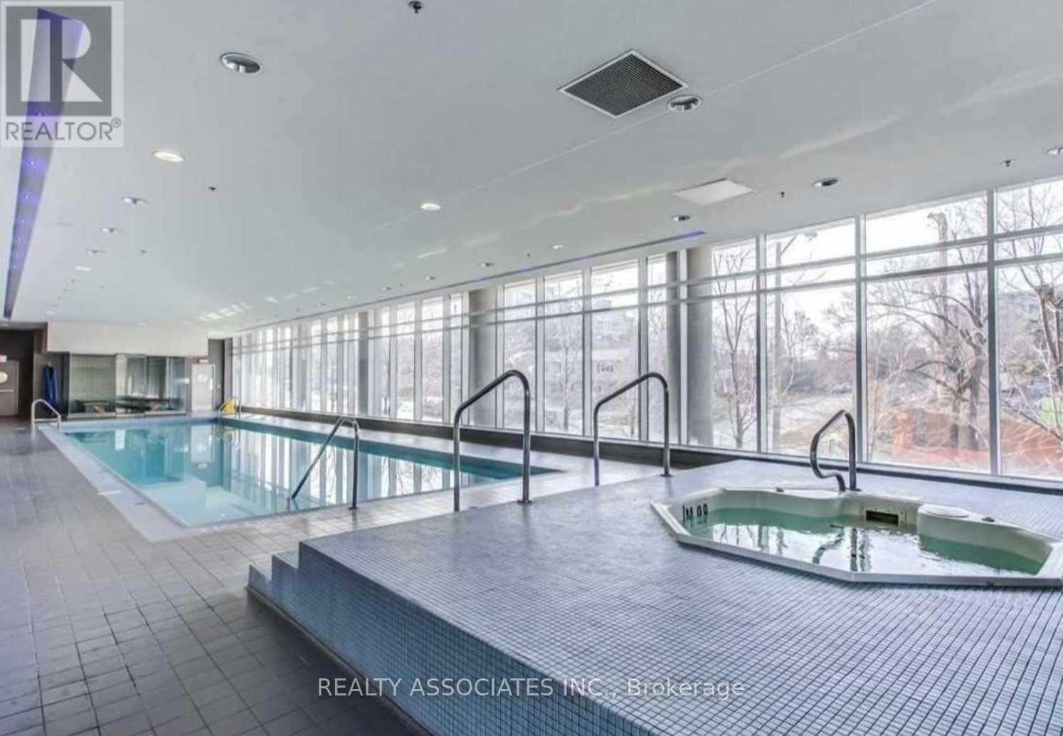 A large indoor swimming pool with a smaller hot tub in the middle.