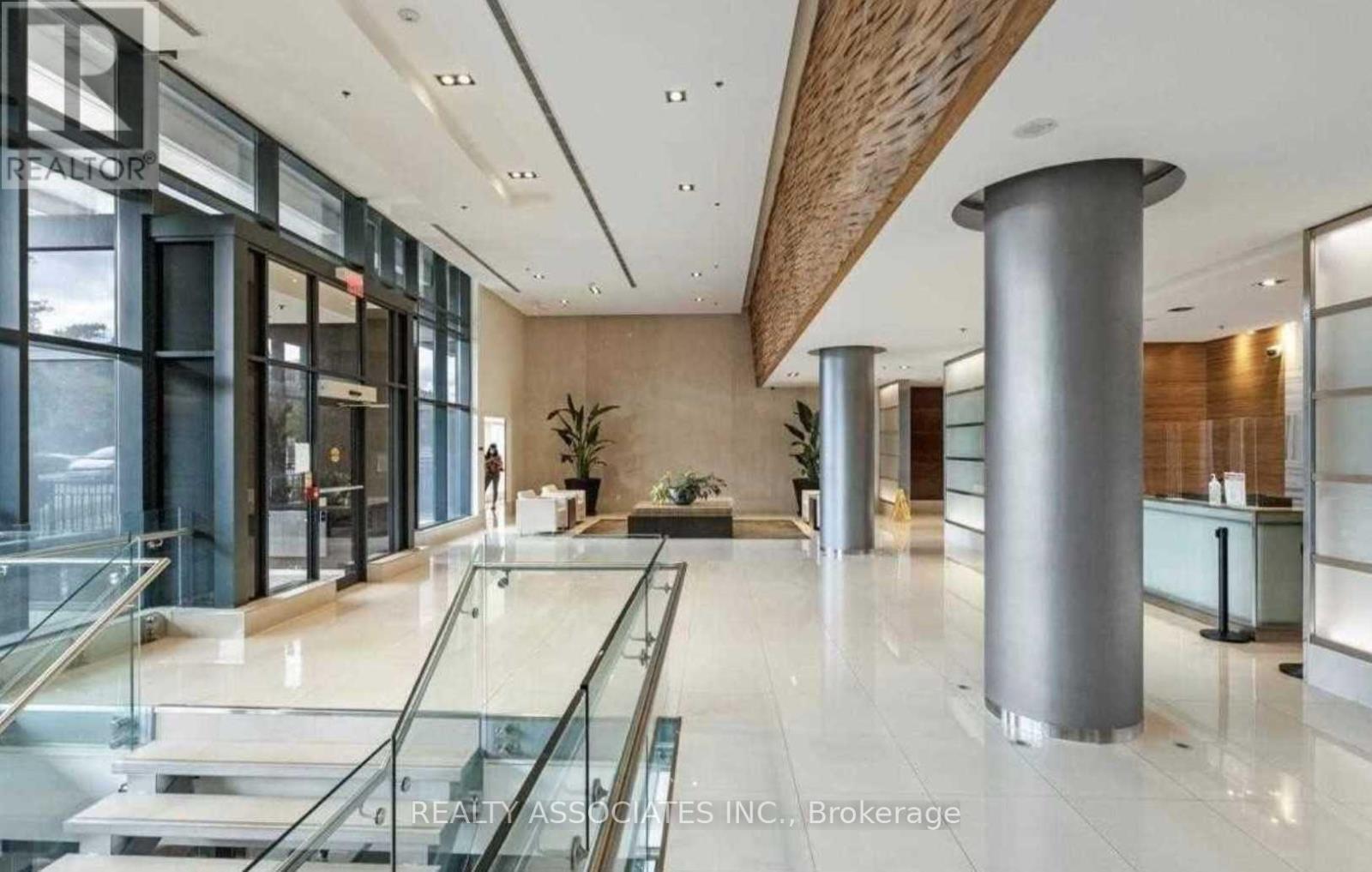 A spacious office lobby with a glass railing and a person standing in the background.