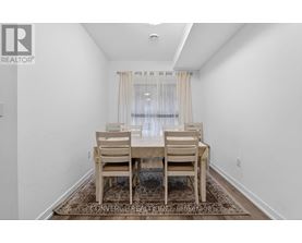 A dining room with a table and chairs.