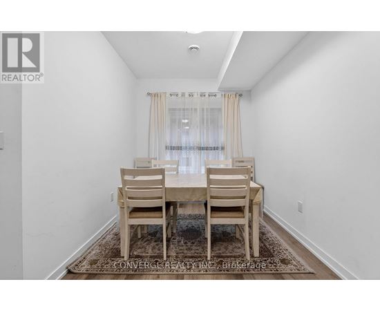 A dining room with a table and chairs.