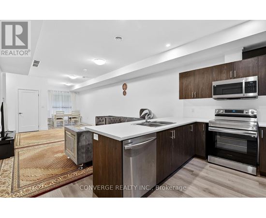 A modern kitchen with dark wood cabinets and stainless steel appliances.