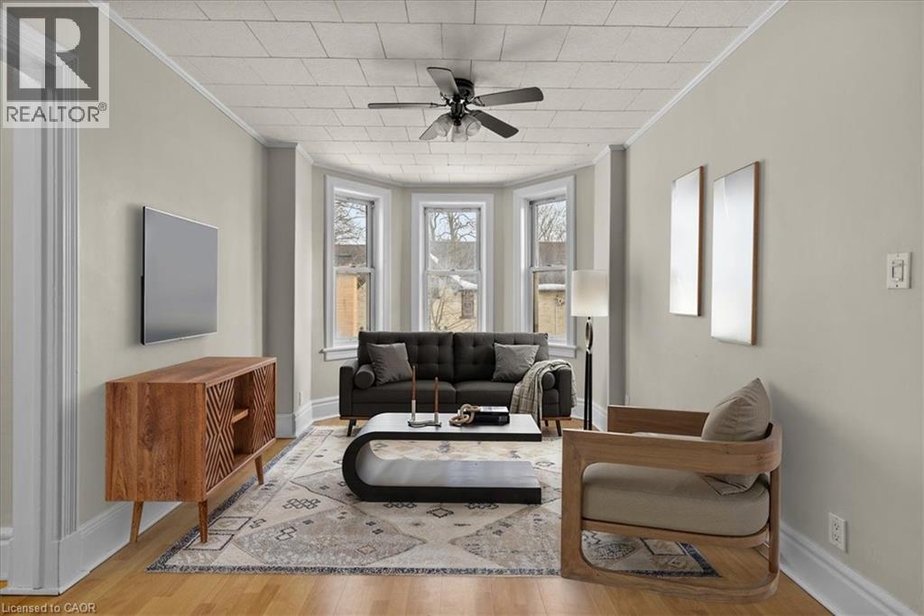 A living room with a black couch and a wooden cabinet.